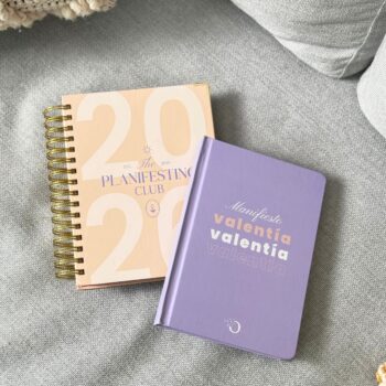 Kit Valentía con agenda espiral 2026 rosa con morado y libreta lila Valentía, fotografía lifestyle sobre sillón.
